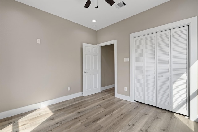 unfurnished bedroom featuring light hardwood / wood-style floors, a closet, and ceiling fan
