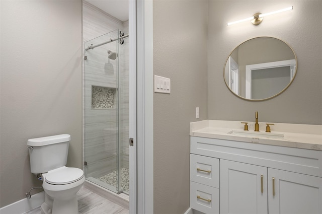 bathroom with vanity, a shower with shower door, and toilet