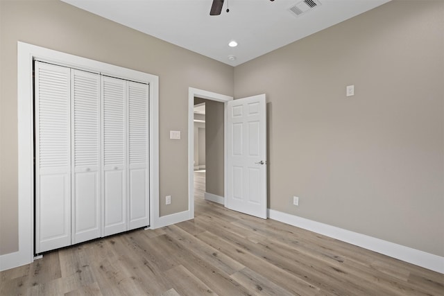 unfurnished bedroom with light hardwood / wood-style flooring, a closet, and ceiling fan