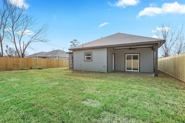 rear view of house featuring a yard and ceiling fan