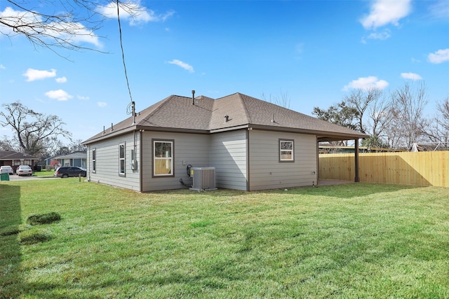back of house featuring a yard and central air condition unit