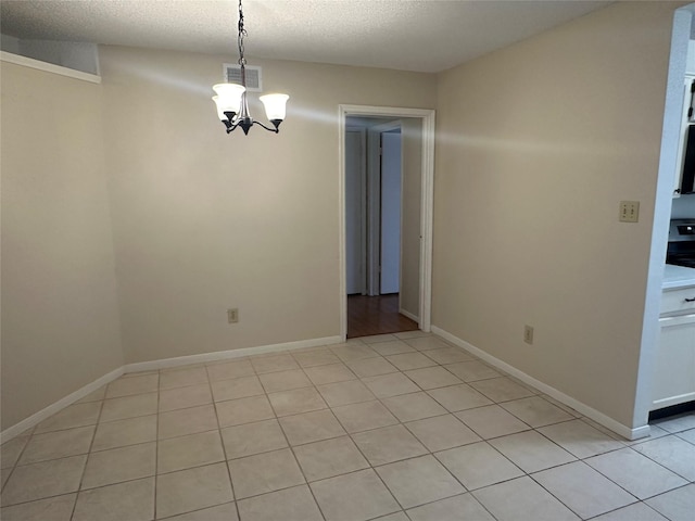 unfurnished dining area with light tile patterned flooring, a textured ceiling, and a notable chandelier