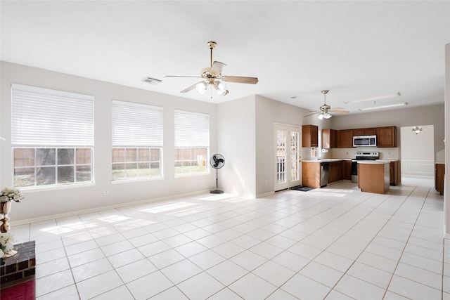 unfurnished living room with light tile patterned flooring, ceiling fan, and sink