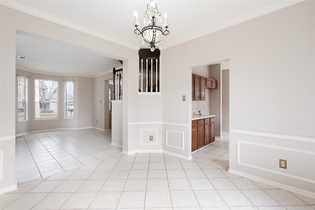 spare room with ornamental molding, light tile patterned flooring, and a chandelier