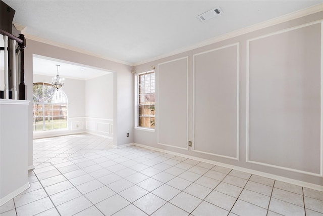 tiled spare room featuring a healthy amount of sunlight, a notable chandelier, and ornamental molding