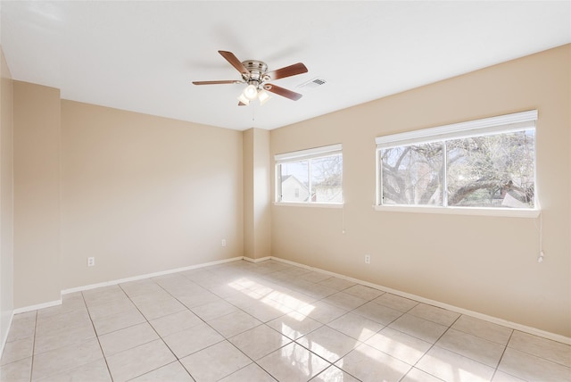 tiled spare room with ceiling fan