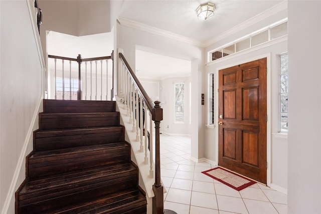 tiled foyer with crown molding and a textured ceiling