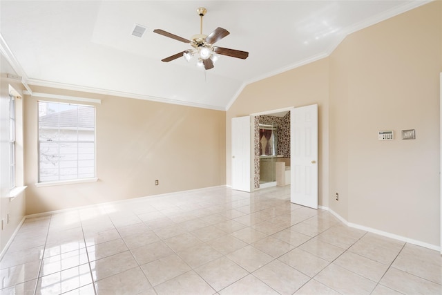 empty room featuring light tile patterned floors, ceiling fan, vaulted ceiling, and ornamental molding