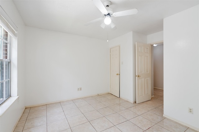 spare room with light tile patterned flooring and ceiling fan