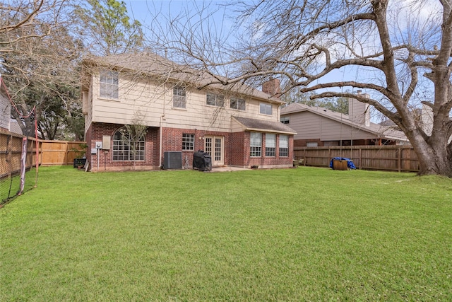 rear view of property with central AC and a lawn