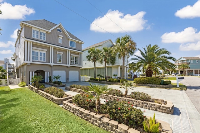 view of front of home featuring driveway, an attached garage, fence, and a front yard