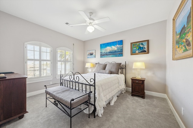 bedroom with baseboards, ceiling fan, visible vents, and light colored carpet