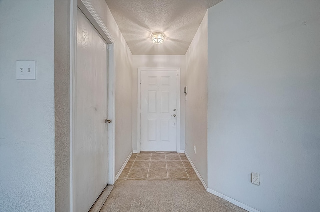 doorway to outside with a textured ceiling