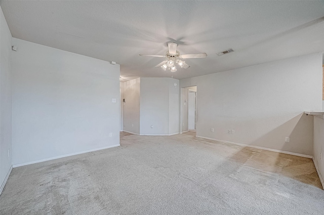 carpeted spare room featuring a textured ceiling and ceiling fan