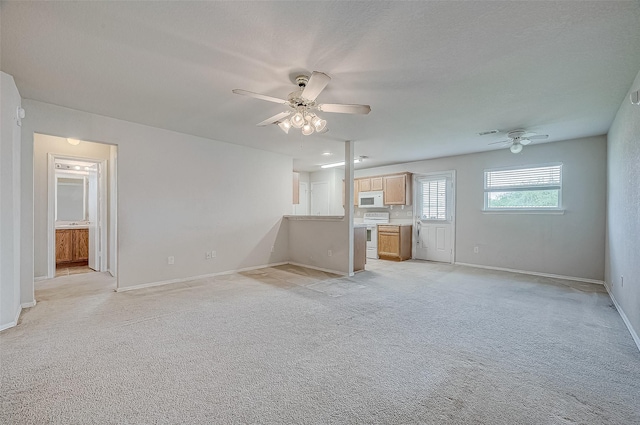 unfurnished living room featuring ceiling fan, light colored carpet, and a textured ceiling