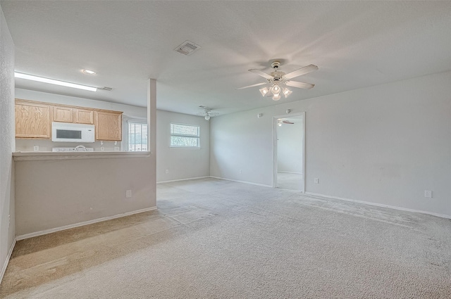 unfurnished living room with light colored carpet, a textured ceiling, and ceiling fan