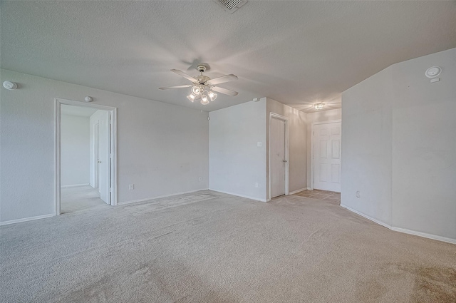 unfurnished room with light carpet, ceiling fan, and a textured ceiling