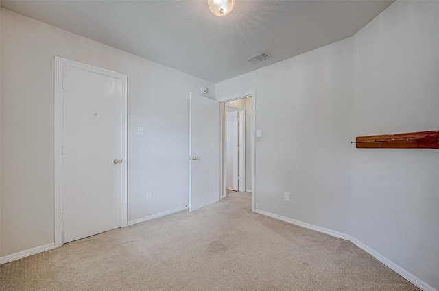 carpeted spare room featuring a textured ceiling