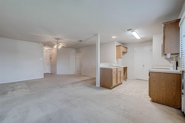 kitchen with light carpet, sink, ceiling fan, and range