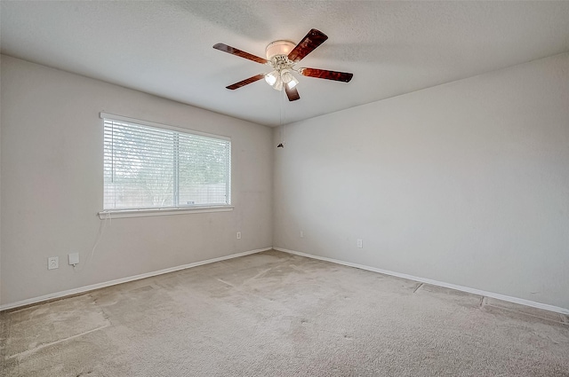 unfurnished room featuring a textured ceiling, light colored carpet, and ceiling fan