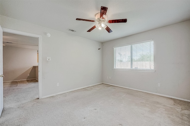 empty room featuring light colored carpet and ceiling fan