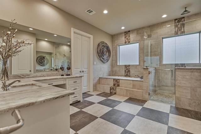 full bathroom featuring recessed lighting, vanity, visible vents, a bath, and a stall shower