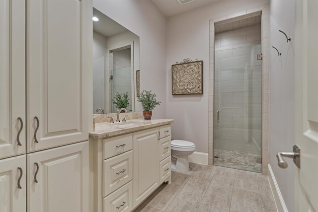 full bathroom with toilet, a stall shower, baseboards, and vanity