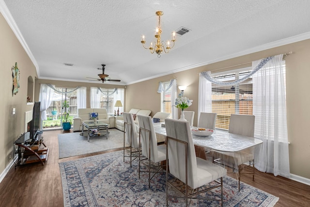 dining room featuring dark wood-type flooring, ornamental molding, and a textured ceiling