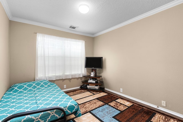 bedroom featuring crown molding, hardwood / wood-style floors, and a textured ceiling