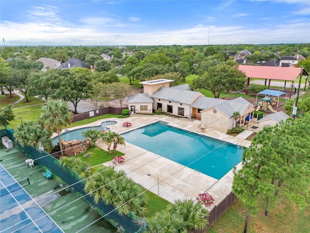 community pool with fence and a patio