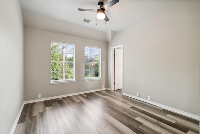 unfurnished room with ceiling fan, wood finished floors, visible vents, and baseboards