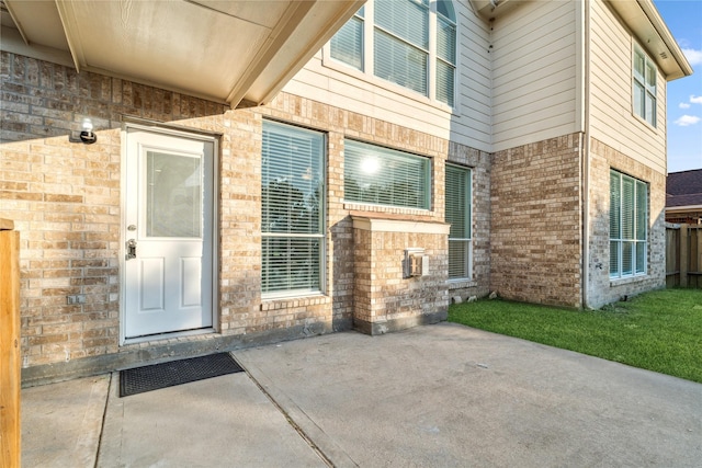 doorway to property with a patio area and brick siding