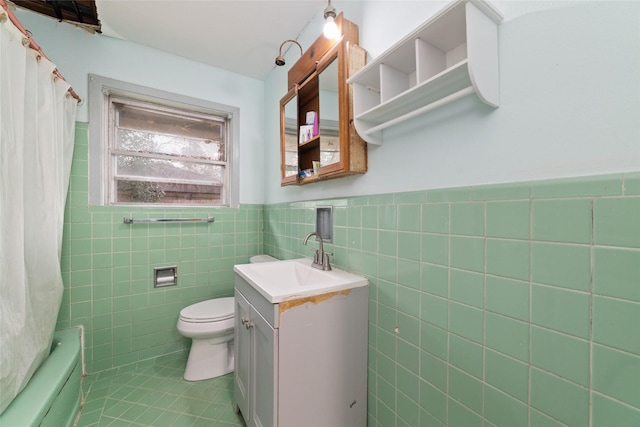 bathroom with tile patterned flooring, vanity, tile walls, and toilet