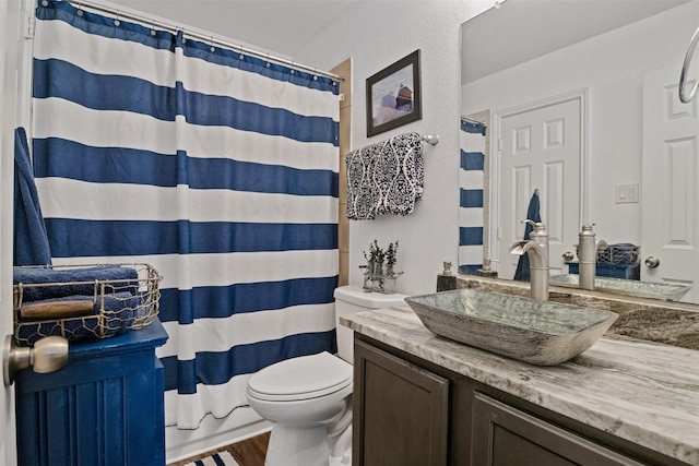 bathroom featuring hardwood / wood-style flooring, toilet, and vanity