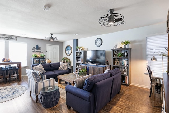 living room featuring a textured ceiling, dark hardwood / wood-style flooring, and ceiling fan