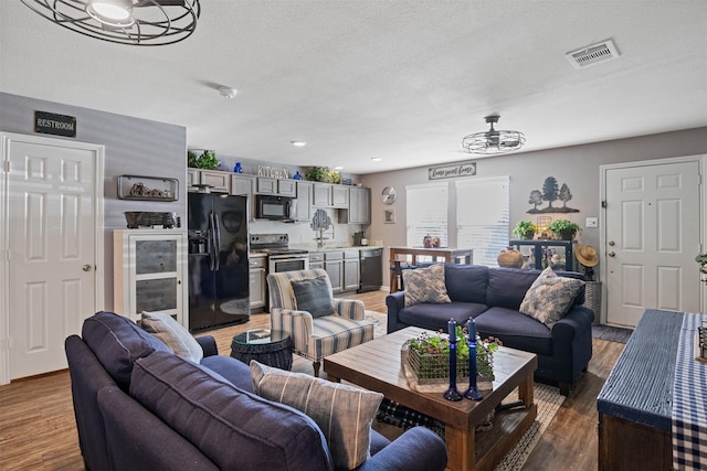 living room with wood-type flooring and a textured ceiling