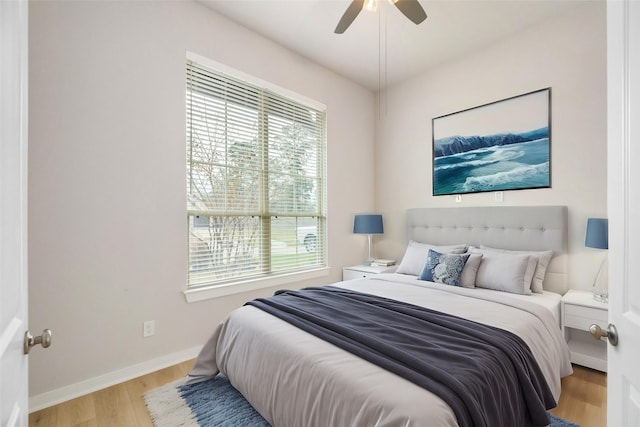 bedroom with light wood-style flooring, baseboards, and ceiling fan