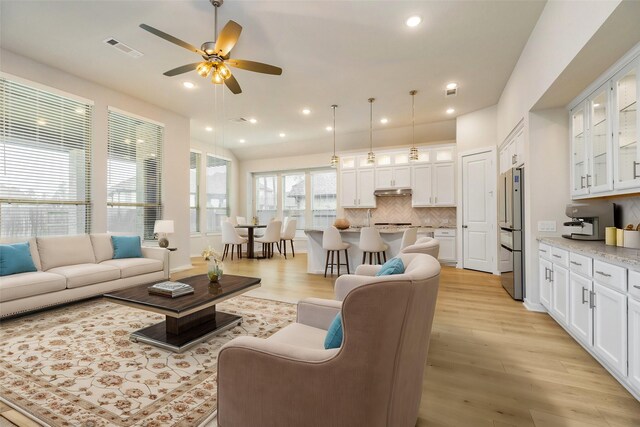 living area featuring light wood-style floors, visible vents, a ceiling fan, and recessed lighting