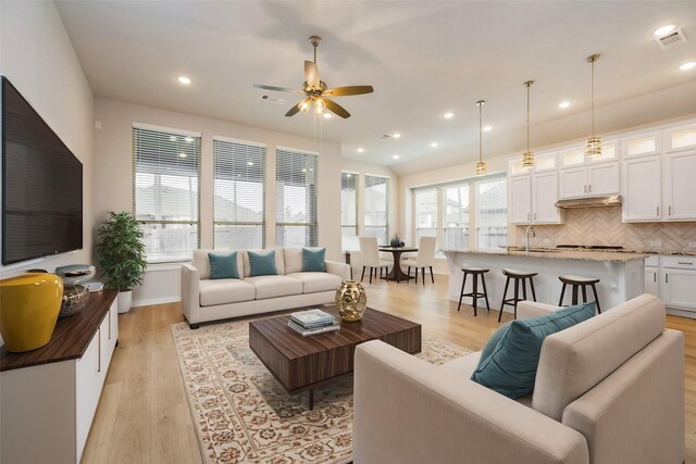 living area with light wood finished floors, ceiling fan, visible vents, and recessed lighting