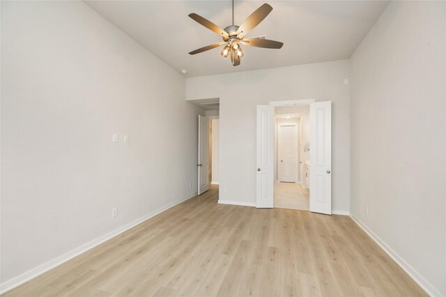 unfurnished bedroom with light wood-type flooring, ceiling fan, baseboards, and ensuite bathroom