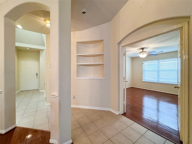 hallway featuring built in features and light tile patterned floors