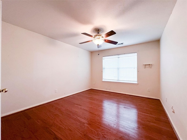 empty room with dark wood-type flooring and ceiling fan