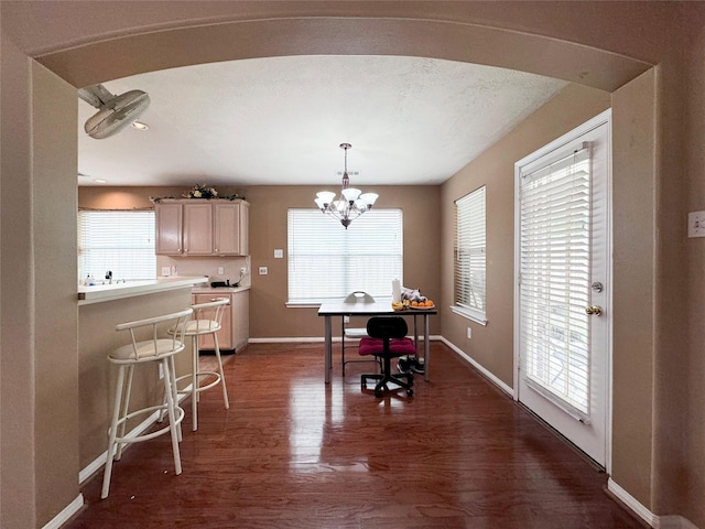 dining room featuring an inviting chandelier, dark hardwood / wood-style floors, and a textured ceiling