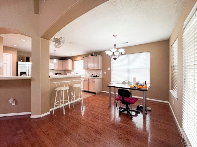 kitchen featuring a wealth of natural light, pendant lighting, light brown cabinets, and stainless steel fridge with ice dispenser