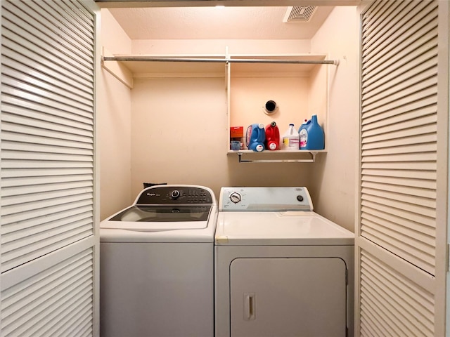 clothes washing area with washer and clothes dryer