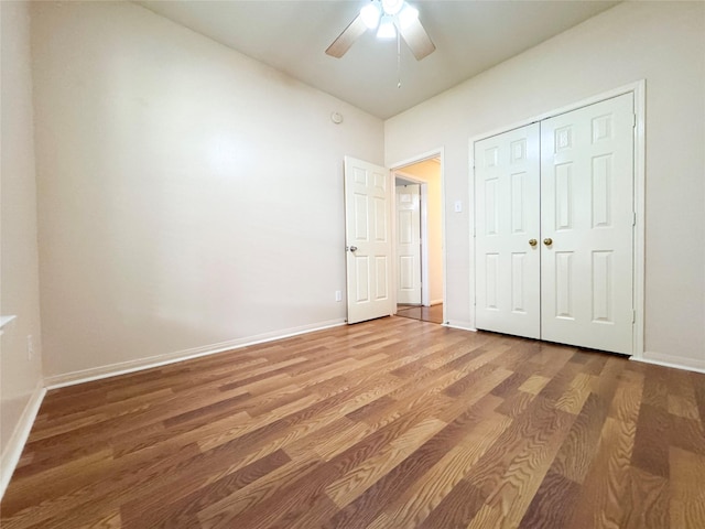 unfurnished bedroom with wood-type flooring, ceiling fan, and a closet