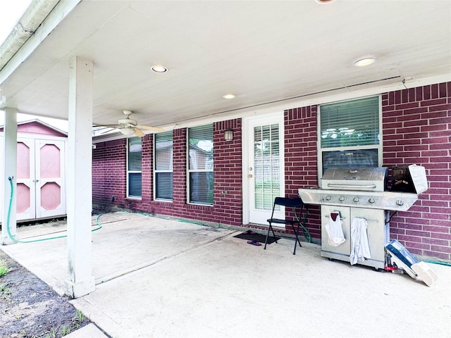 view of patio / terrace featuring area for grilling, ceiling fan, and a shed