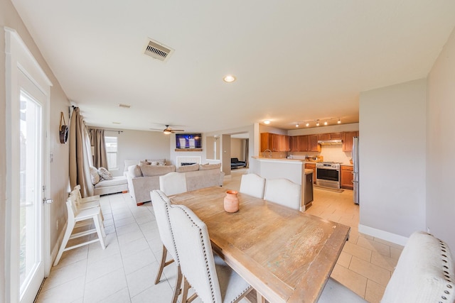 dining room featuring rail lighting, light tile patterned floors, and ceiling fan