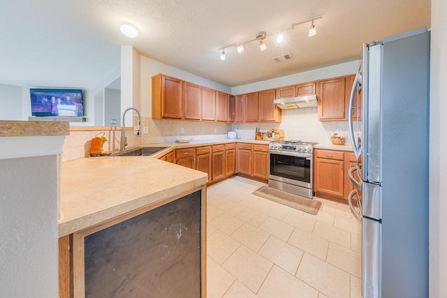 kitchen with light tile patterned flooring, sink, decorative backsplash, kitchen peninsula, and stainless steel appliances