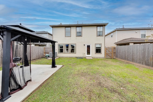 back of property with central AC unit, a gazebo, a patio area, and a lawn